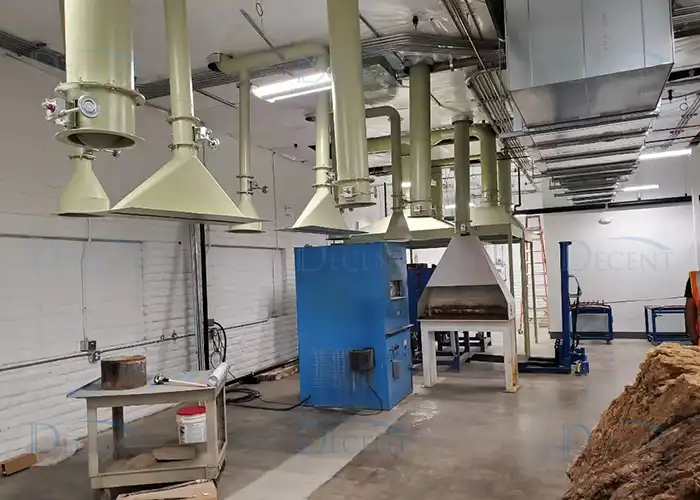 A comprehensive lab dedusting system with multiple exhaust hoods and ductwork connected to industrial machinery, ensuring air quality and safety.