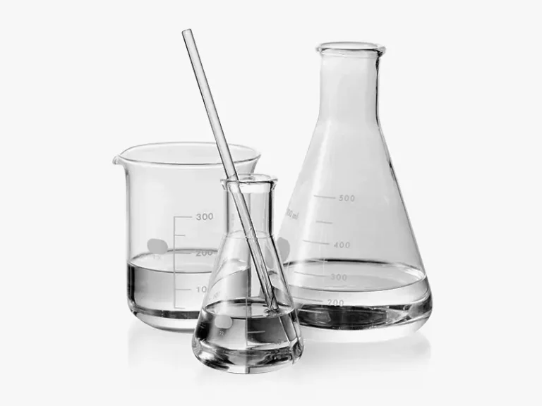Assortment of clear DECENT laboratory glassware including beakers and Erlenmeyer flasks with liquid, and a stirring rod, on a white background.