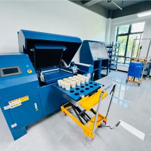 DECENT automated crucible tumbler in a modern laboratory, with a tray of crucibles on a hydraulic lift, ready for sample mixing.