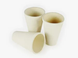 Three DECENT fire assay clay crucibles, two standing upright and one lying on its side, against a white background.