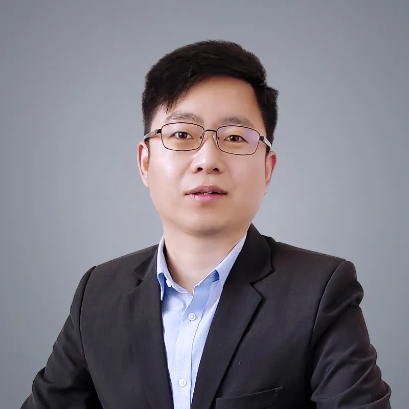 Portrait of Alex Wang, R&D and Production Director at DECENT, wearing glasses and a suit.