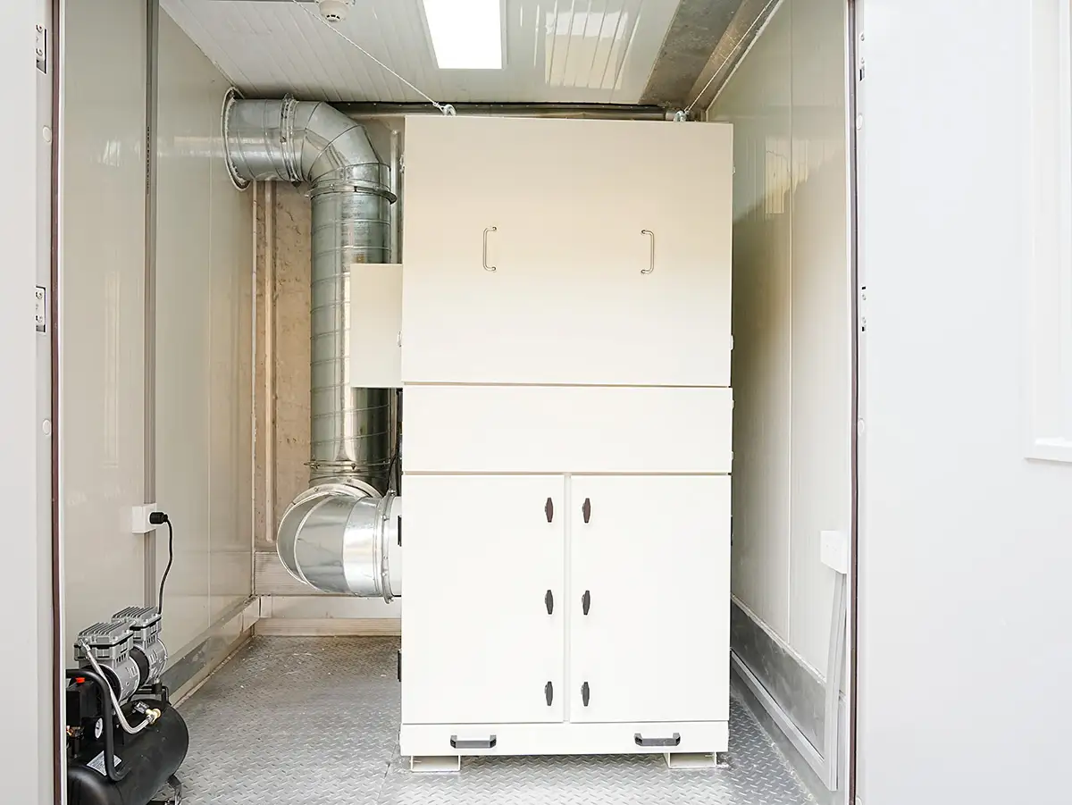 White dust removal filtrater unit with silver ventilation ducts and an air compressor inside a DECENT (Qingdao Decent Group) container laboratory.