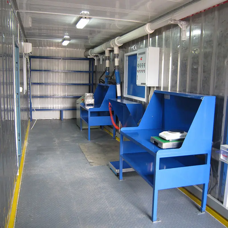 Interior of a DECENT container laboratory of sample preparation showing two blue workstations, wall shelving, and industrial lighting for mobile testing or analysis.