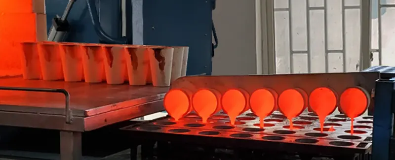 Molten material being poured from crucibles into molds during a fire assay operation, showcasing DECENT's metallurgical process