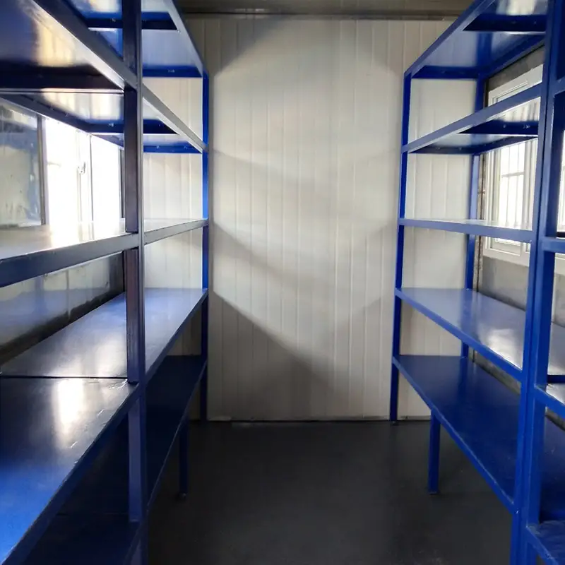 Interior of a DECENT modular container with two rows of blue industrial metal shelving for organized storage.