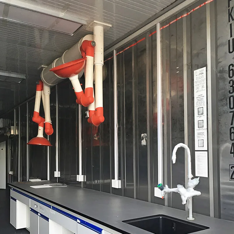 The interior of a containerized laboratory with yellow and blue equipment and a large control panel.