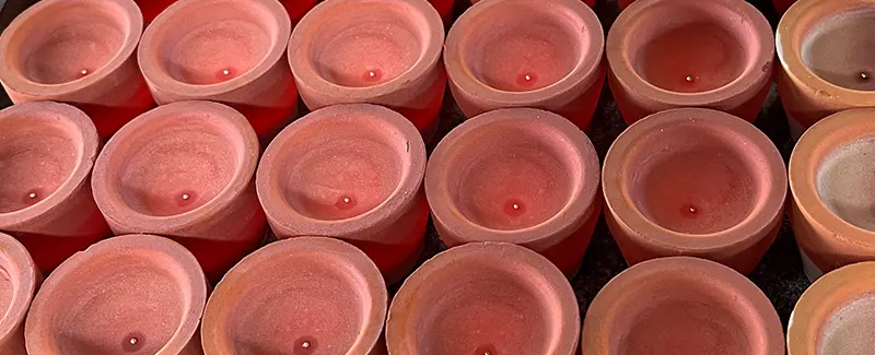 Rows of magnesia cupels, essential for fire assay analysis in mineral processing, highlighting DECENT's quality materials