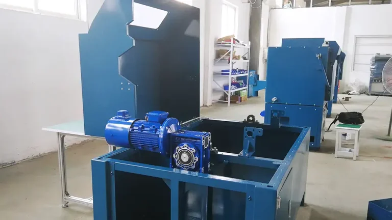 A clean and organized workshop showing blue industrial machine components, including a motor and gearbox, in various stages of assembly, highlighting manufacturing processes