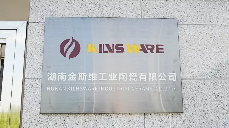 A close-up of a metal sign for "HUNAN KILNSWARE INDUSTRIAL CERAMIC CO.,LTD." with the "KILNSWARE" logo prominently displayed