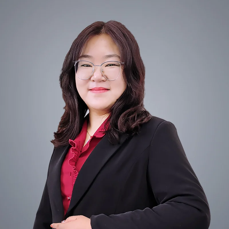 Portrait of Mandy Gao, VP of Global Sales at DECENT, wearing glasses and a red ruffled blouse under a black blazer.