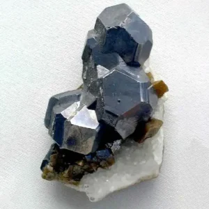 A hexagonal cluster of dark, metallic-gray sphalerite crystals on a white and brownish-yellow matrix, showing their multifaceted forms.