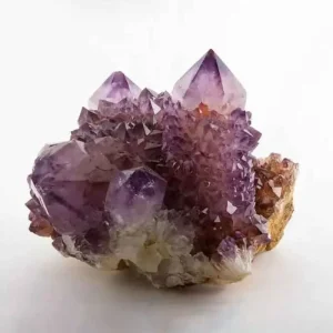 A vibrant purple amethyst crystal geode cluster with varying shades of violet, growing on a light-colored matrix.