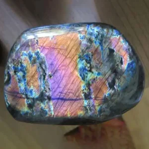 A polished piece of Ealing Stone, also known as labradorite, with a stunning iridescent play of colors including blue, purple, and orange.