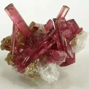 A beautiful cluster of red and pink tourmaline crystals, also known as electric stone, growing on a white and brownish matrix.