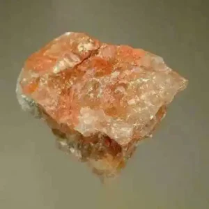 A rough, translucent potash mineral specimen with a mottled pinkish-orange and white appearance, showing its crystalline structure.