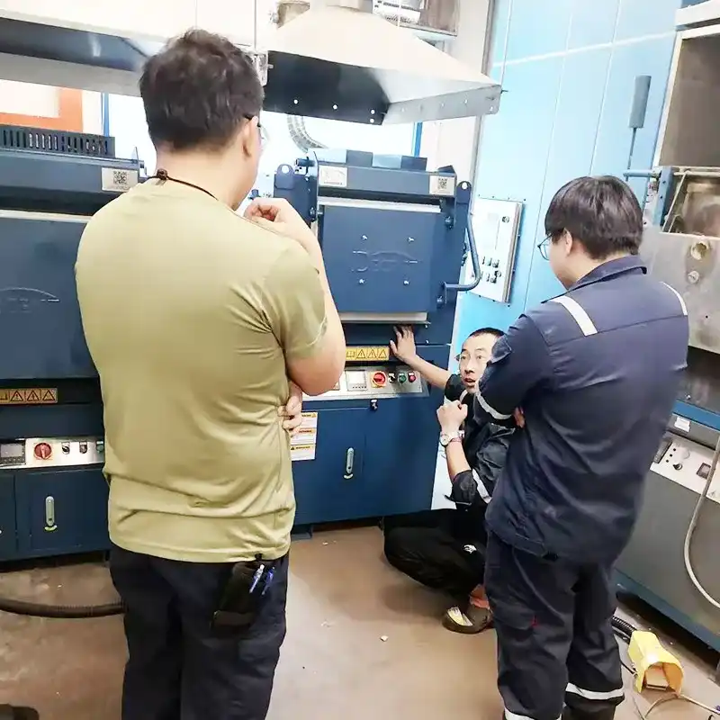 Qingdao Decent Group team member instructing laboratory staff on a DECENT fire assay furnace in Singapore.
